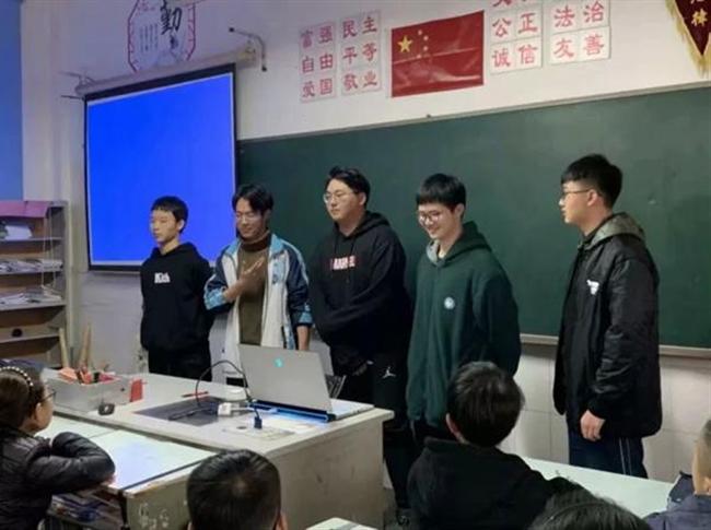 A group of people standing in a room

Description automatically generated