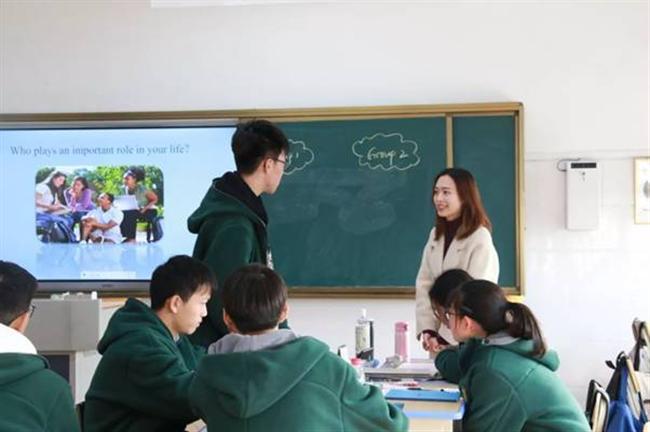 A group of people standing in a room

Description automatically generated