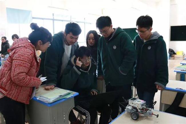 A group of people standing around a table

Description automatically generated