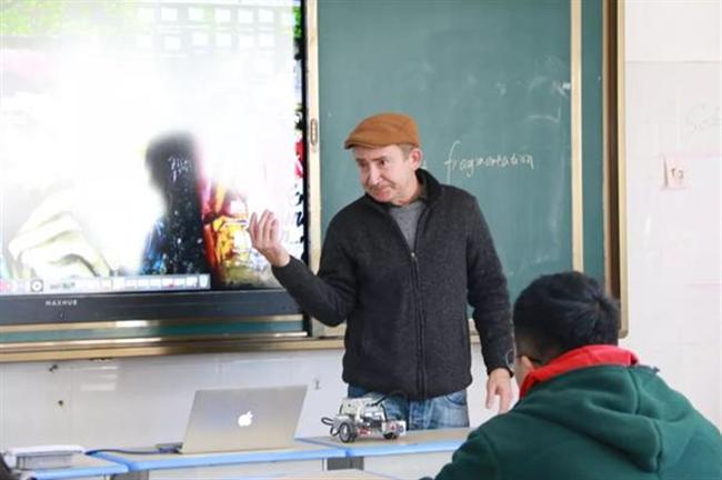 A person standing in front of a screen

Description automatically generated