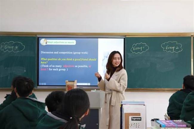 A group of people standing in front of a screen

Description automatically generated