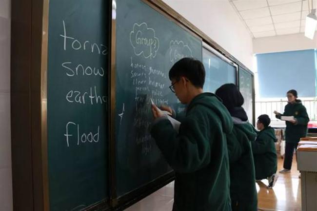 A person standing in front of a blackboard

Description automatically generated