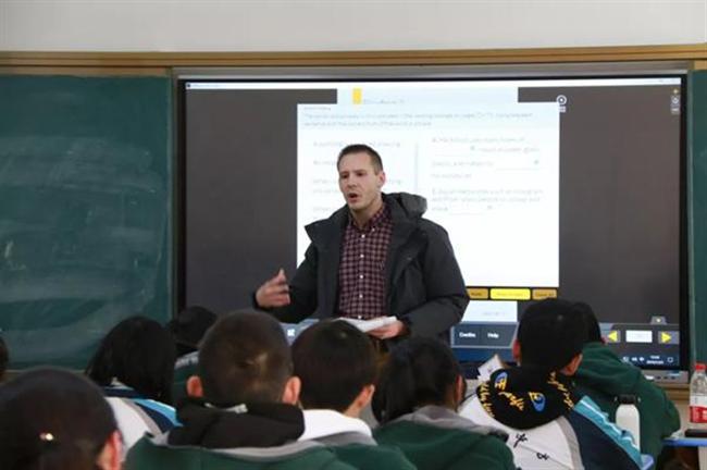 A group of people sitting at a desk

Description automatically generated