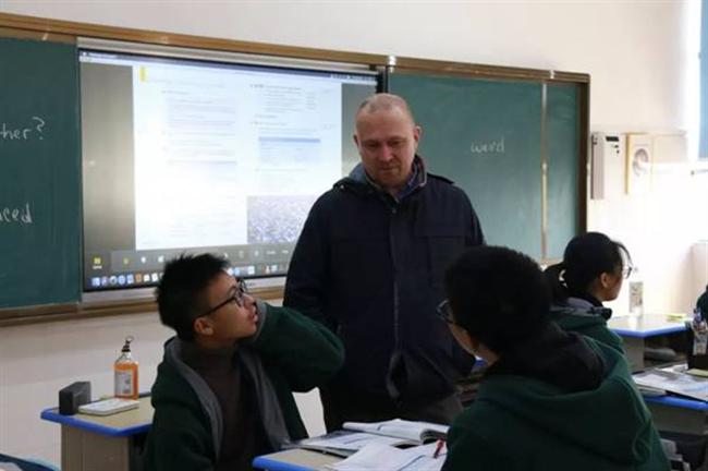 A group of people sitting at a desk

Description automatically generated