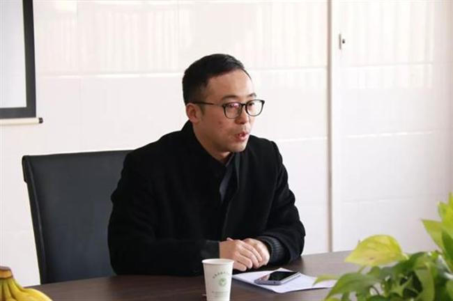 A person sitting at a table using a computer

Description automatically generated